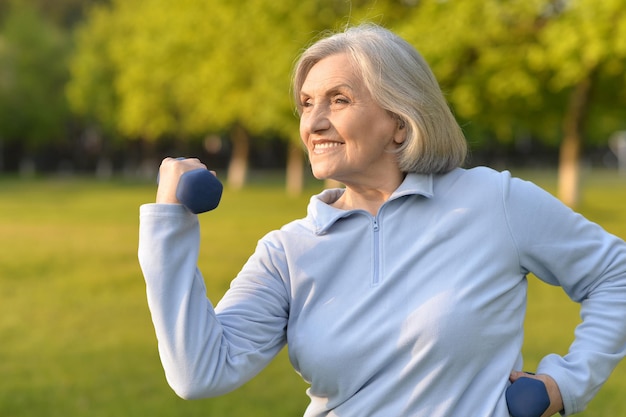 Glückliche ältere Frau, die im Sommer Sport in der Natur macht