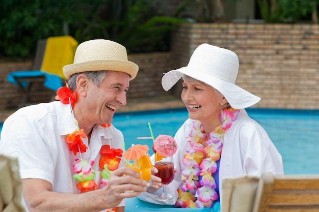 Glückliche ältere Paare, die Cocktails trinken und einander rösten