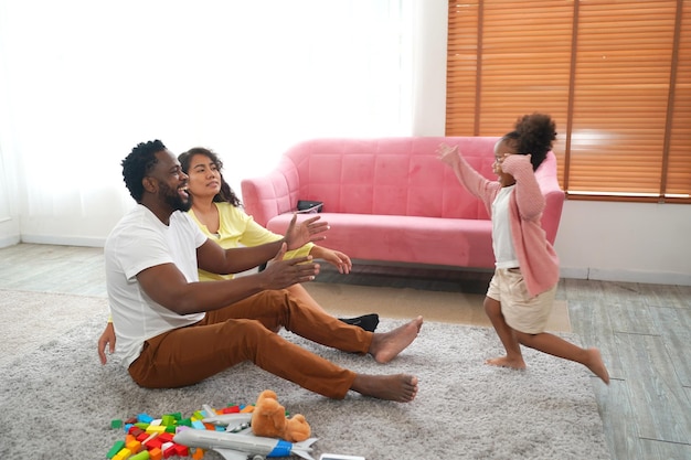 Glückliche afrikanische Familie, die zu Hause spielerische Zeit hat Familienliebe Eltern und Kleinkind drinnen