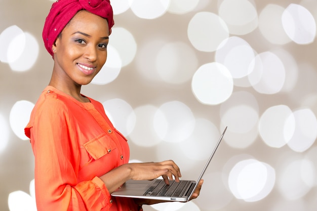 Glückliche Afroamerikanerfrau mit Laptop