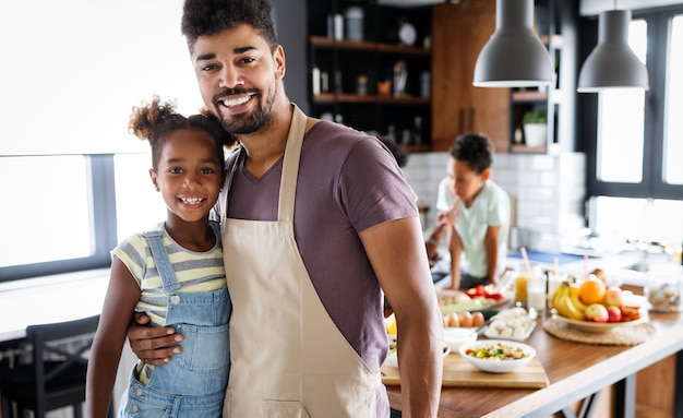 Glückliche afroamerikanische Familie, die gemeinsam gesunde Bio-Lebensmittel in der Küche zubereitet