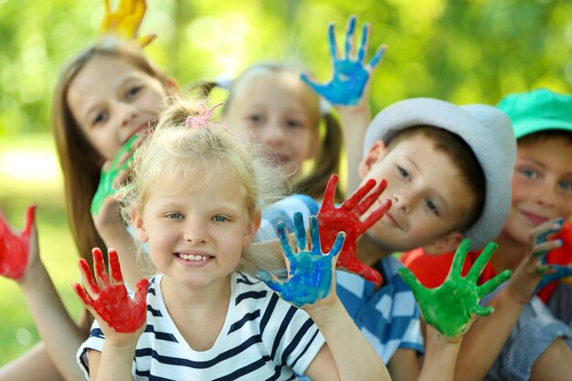 Glückliche aktive Kinder mit bunten Palmen im Park