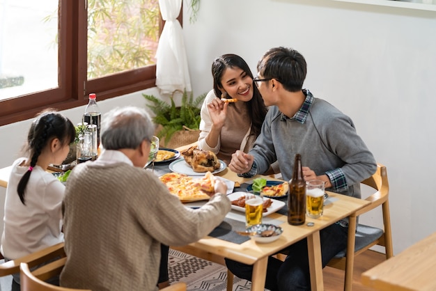 Glückliche asiatische Familie, die Mittagessen zu Hause zusammen isst