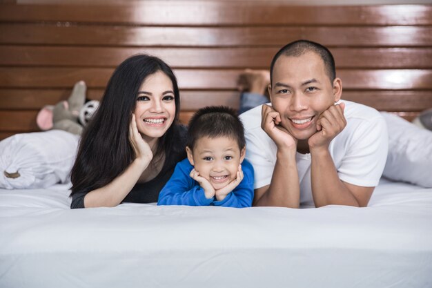 Glückliche asiatische Familie im Bett