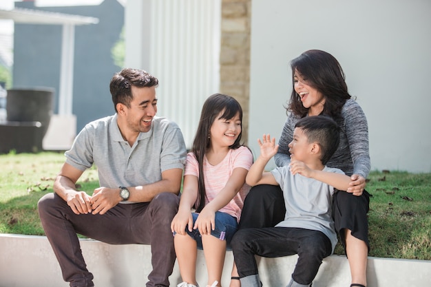 Glückliche asiatische Familie vor ihrem Haus