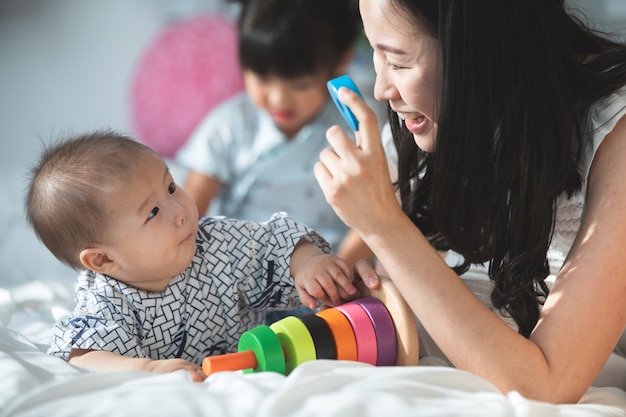 Glückliche asiatische Familienvatermutter mit der Tochter, die Kamera mit Lächelngesicht schaut.