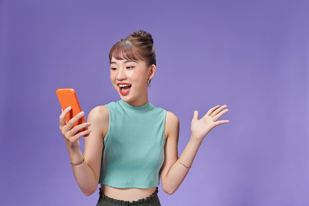Foto glückliche asiatische frau, die sich glücklich fühlt und smartphone hält