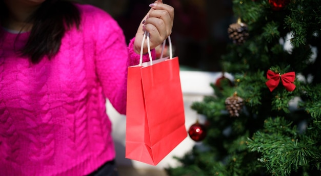 Foto glückliche asiatische mädchen halten einkaufstaschen weihnachtsgeschenk fröhliche frau mit weihnachten neujahr winterschlussverkauf