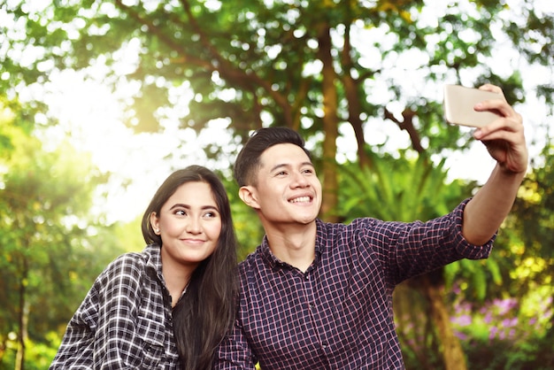 Glückliche asiatische Paare, die ein selfie mit Telefon nehmen