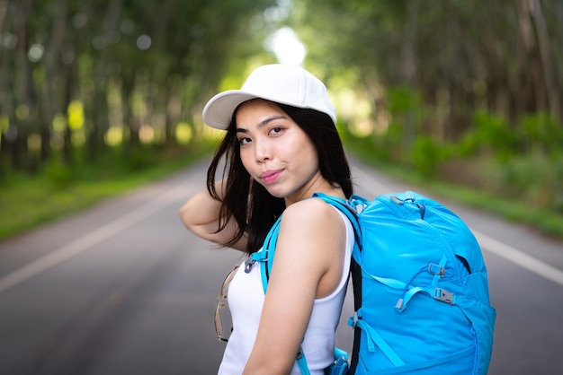 Glückliche asiatische Studentin reist mit dem Rucksack in den Sommerferien von der Ausbildung am Berg