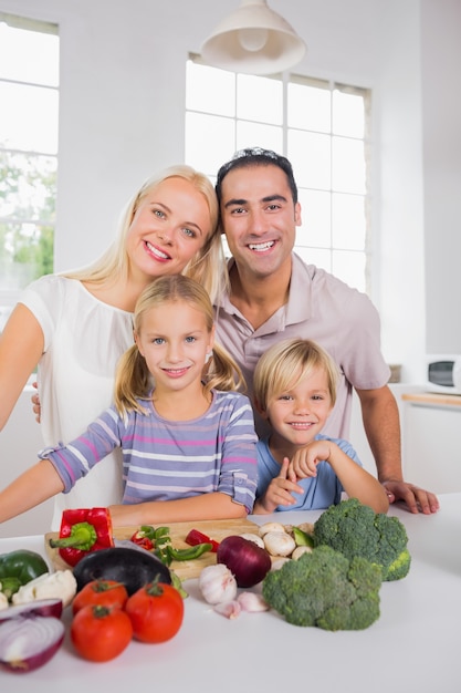 Glückliche aufwerfende Familie, die ein Abendessen vorbereitet