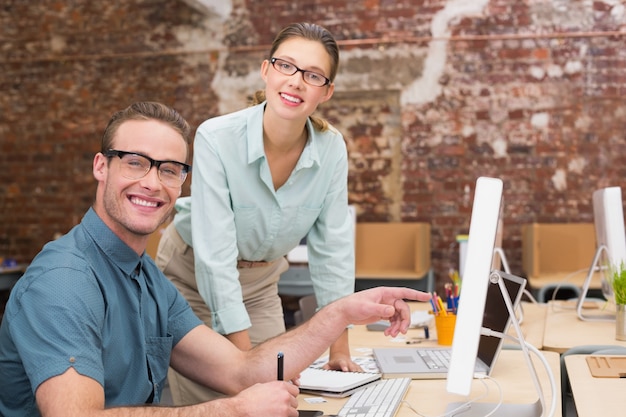 Glückliche beiläufige Bildeditoren bei der Arbeit im Büro