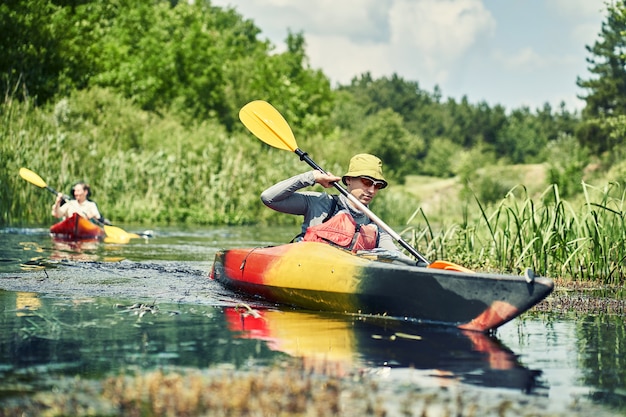 Glückliche beste Freunde, die Spaß auf einem Kajak haben. Kajakfahren auf dem Fluss.