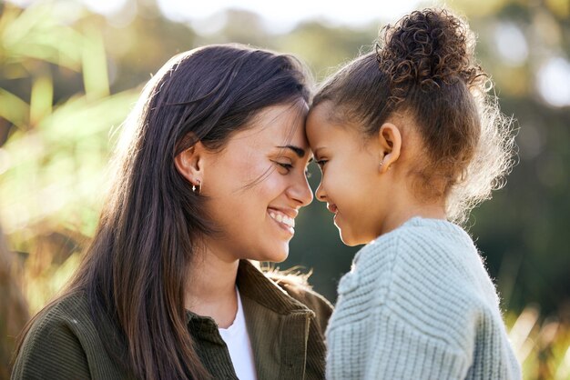 Foto glückliche bindung und mutter und kind in der natur für liebe, dankbarkeit und freundlichkeit am muttertag. lächeln sie ruhig und eine junge mutter mit einem mädchen und glücklicher fürsorge und gemeinsam in einem park für eine schöne zeit