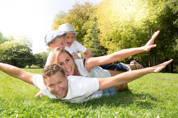 Glückliche blonde Familie, die Spaß im Park hat