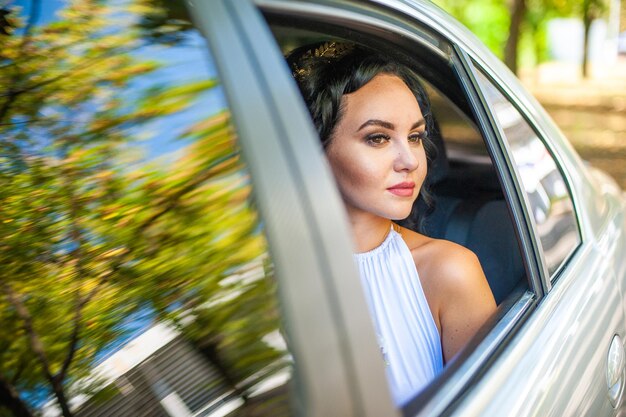 Glückliche Braut, die im Auto sitzt