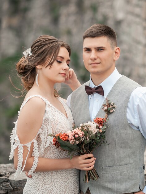 Glückliche Braut und Bräutigam an ihrem Hochzeitstag posieren