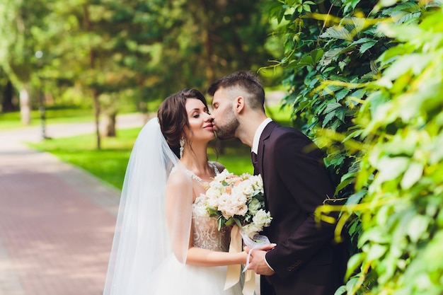 glückliche Braut und Bräutigam in einem Park an ihrem Hochzeitstag
