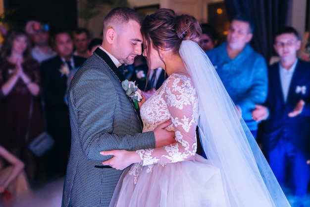 Glückliche Braut und Bräutigam und ihre erste Tanzhochzeit in einem eleganten Restaurant mit wunderbarem Licht und Atmosphäre