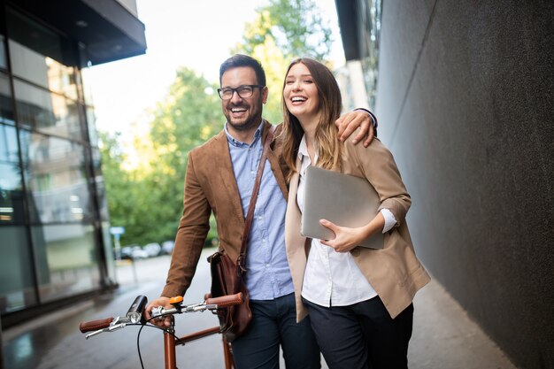 Glückliche Bürofrau mit Geschäftsmannpaar, das eine Pause genießt, während sie im Freien flirtet