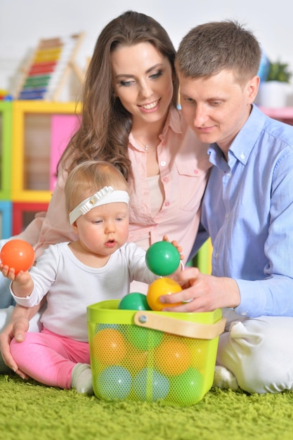 Glückliche Eltern, die mit kleiner Tochter spielen