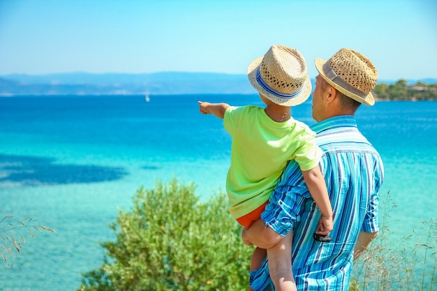 Glückliche Eltern mit Kind durch das Meer Griechenland im Freien