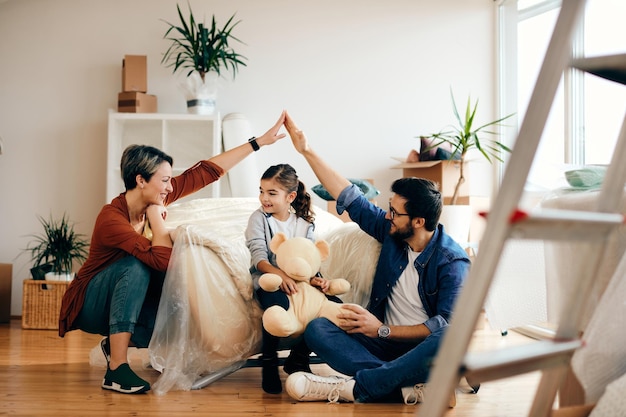 Glückliche Eltern mit Tochter, die in eine neue Wohnung zieht