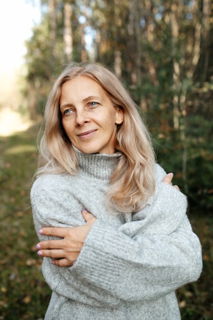 Glückliche erwachsene Frau im Herbstwald