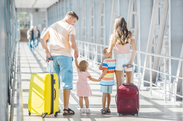 Glückliche Familie am Flughafen mit Koffern unterwegs