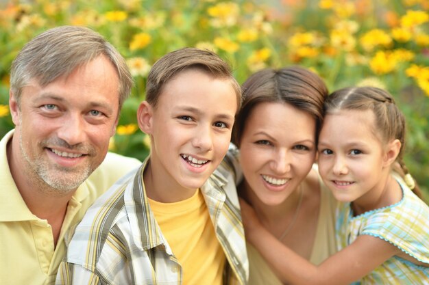 Glückliche Familie am grünen blühenden Feld des Sommers