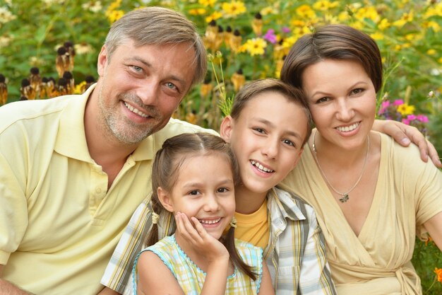 Glückliche Familie am grünen blühenden Feld des Sommers