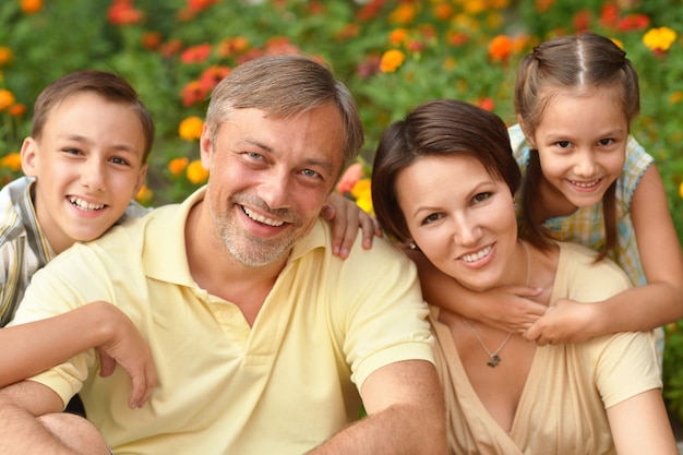 Glückliche Familie am grünen blühenden Feld des Sommers