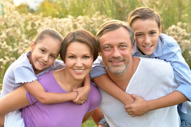 Glückliche Familie am grünen blühenden Feld des Sommers