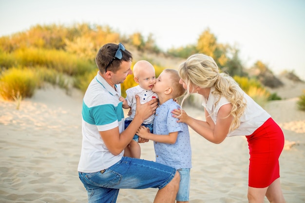 Foto glückliche familie am strand zwischen den sanddünen eine familie mit einem zwei kleinen sohn