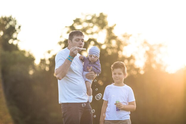 Glückliche Familie auf dem Feld. Sie haben Spaß beim Spielen und Blasen