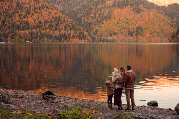 Glückliche familie auf dem see in den bergen für einen spaziergang im herbst