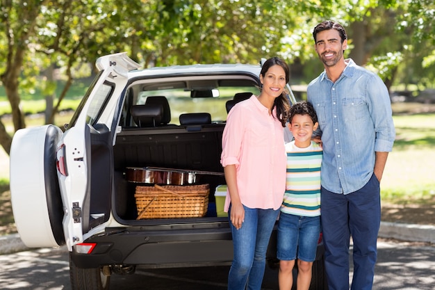 Glückliche Familie auf einem Picknick, das neben ihrem Auto steht