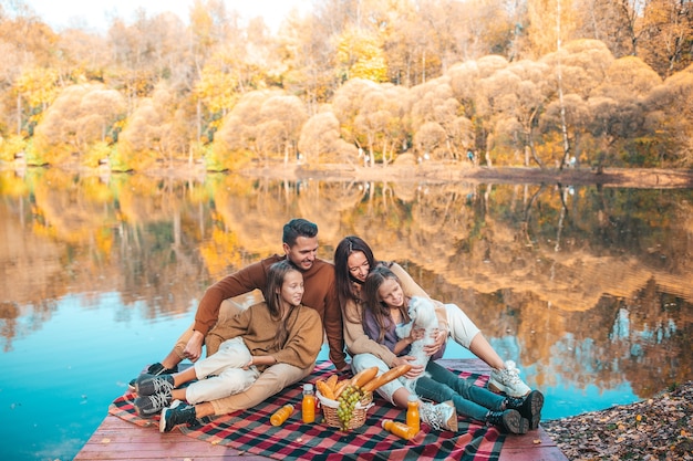 Glückliche Familie auf einem Picknick im Park im Herbst