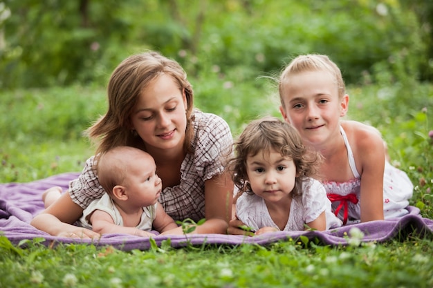 Glückliche Familie auf grünem Gras im Garten