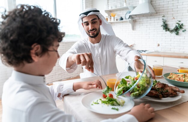 Glückliche Familie aus den arabischen Vereinigten Emiraten, die zusammen essen und die Nationalfeiertage feiern