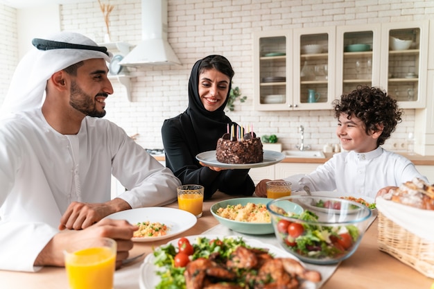 Glückliche Familie aus den arabischen Vereinigten Emiraten, die zusammen essen und die Nationalfeiertage feiern