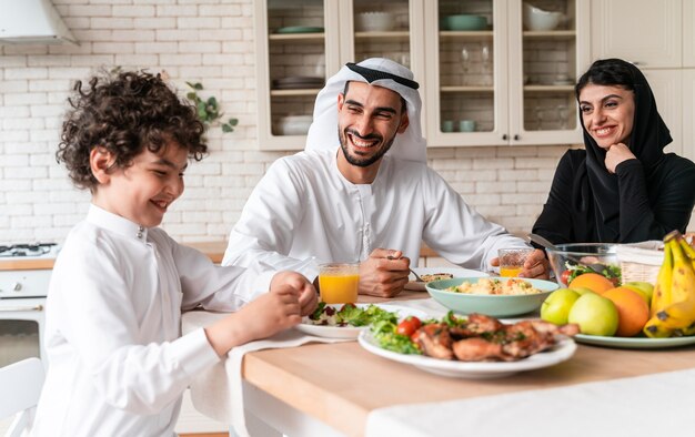 Glückliche Familie aus den arabischen Vereinigten Emiraten, die zusammen essen und die Nationalfeiertage feiern