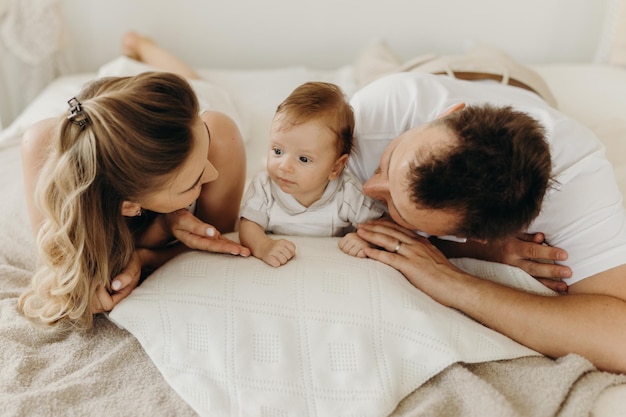 Glückliche Familie der Eltern und des Babys, die Spaß im Bett haben Porträt glückliche Familie