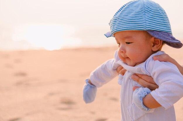 Glückliche Familie, die am Meer entspannt. Glückliche Familie, die im Sommer am Strand ruht. Mutter mit Baby, das am Strand ruht.