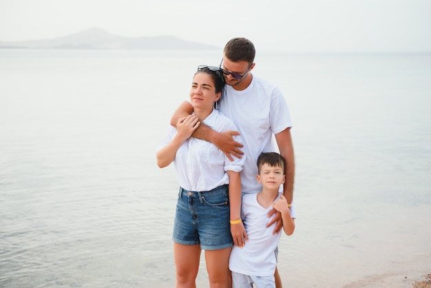 Glückliche Familie, die am Strand spazieren geht