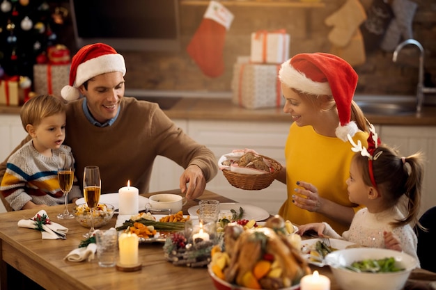 Glückliche Familie, die am Weihnachtstag am Esstisch zu Mittag isst