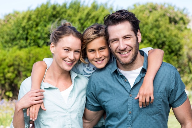 Glückliche Familie, die an der Kamera lächelt