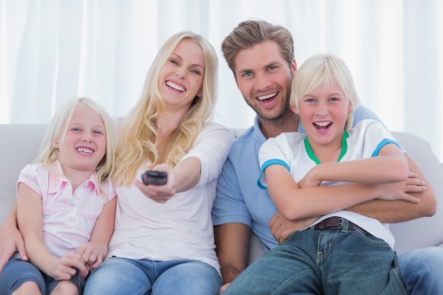 Glückliche Familie, die auf Couch sitzt