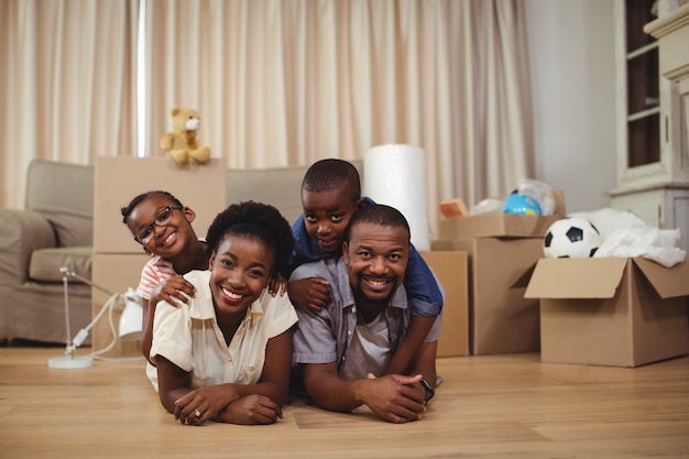 Glückliche Familie, die auf dem Bett übereinander liegt