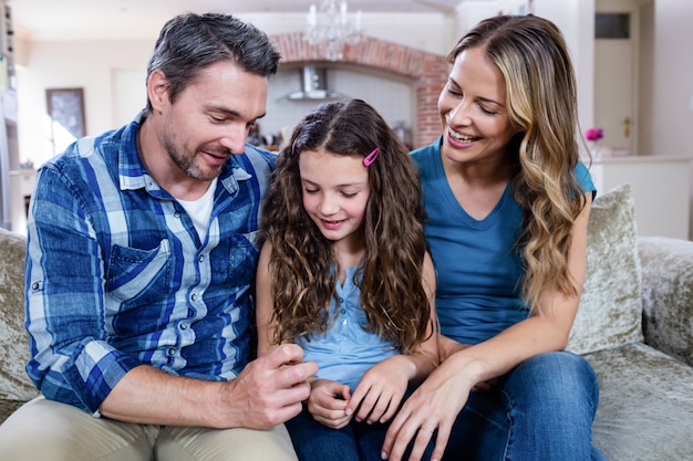 Glückliche Familie, die auf einem Sofa sitzt